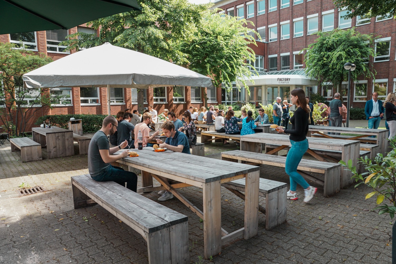 Coworker bei einem Community Grillen im Outdoor Bereich des Factory Campus